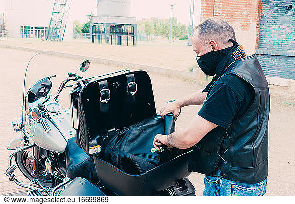 Motorradfahrer packt Jacke in Motorradkoffer