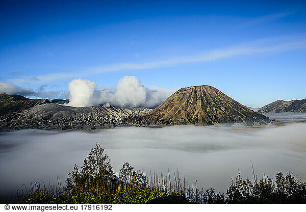 Mount Bromo volcano  a somma volcano and part of the Tengger mountains range  the cone rising above low cloud in the landscape.