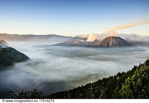 Mount Bromo volcano  a somma volcano and part of the Tengger mountains range  the cone rising above mist in the landscape.