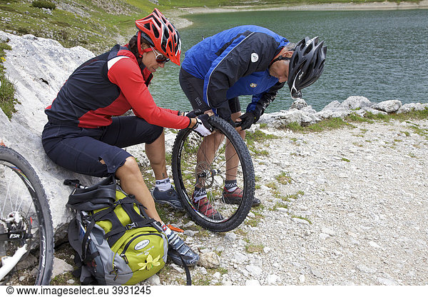 Mountain bike riders repairing a flat front tyre