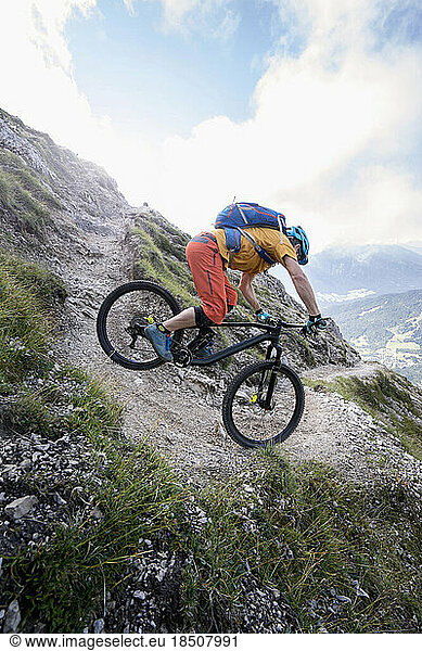 Mountain biker rides a narrow curve downhill  Tirol  Austria