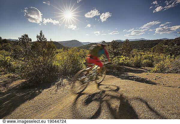 Mountain biker with motion blur riding a trail in the outdoors.
