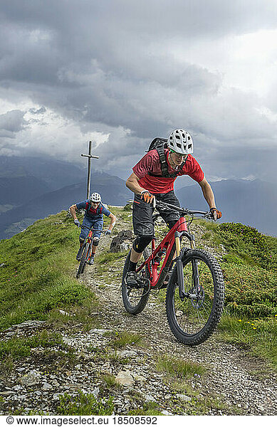 Mountain bikers riding on uphill in alpine landscape  Trentino-Alto Adige  Italy