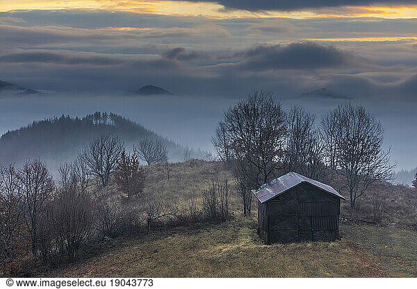 Mountain village in foggy winter morning