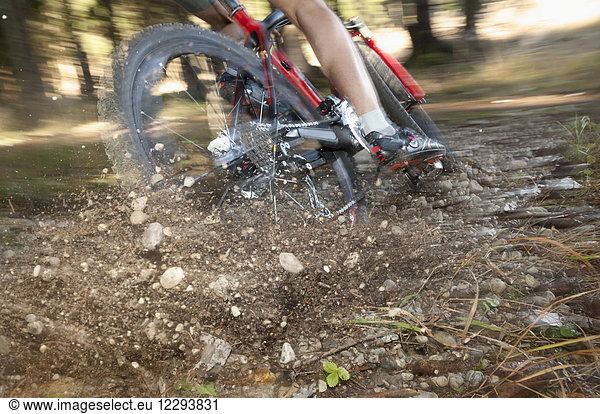 Mountainbiker bremst hart und Steine spritzen