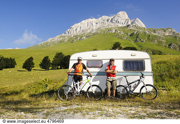 Mountainbiker vor Wohnwagen bei Prati di Tivo am Corno Grande-Gipfel  Nationalpark Gran Sasso  Abruzzen  Italien  Europa