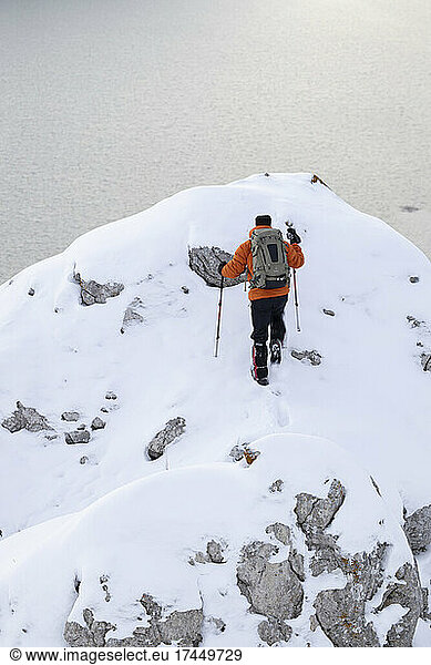 mountaineer crowning snowy summit in barrios de luna reservoir