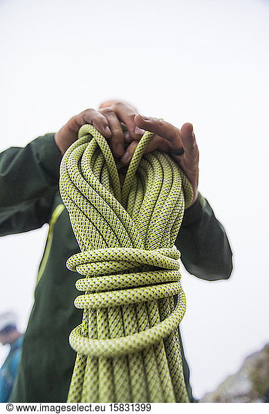 Mountaineer holds coiled climbing rope.