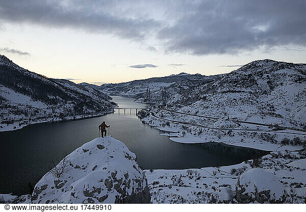 mountaineer observe Barrios de Luna reservoir snowed at sunrise