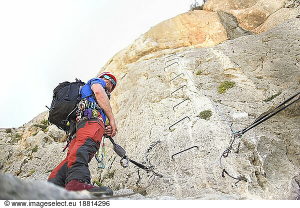 Mountaineer standing near rocky mountain