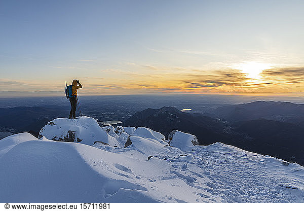 Mountaineer standing on top of a snowy mountain enjoying the view  Lecco  Italy