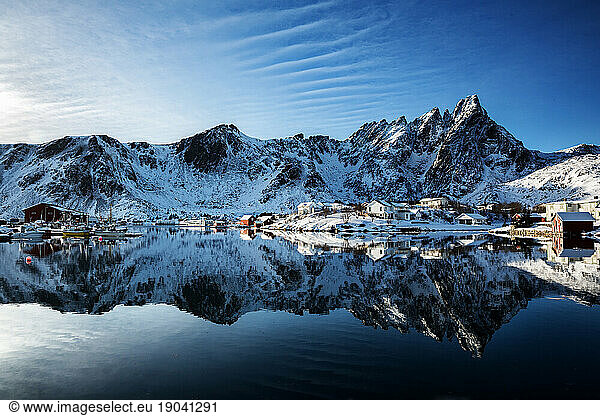 Mountains and village in Norway with reflection in the sea  winter