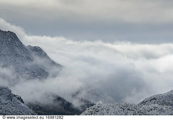mountains between clouds with snowy landscape at winter