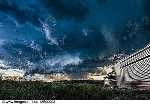 Moving truck heading toward a huge storm and cloud sky