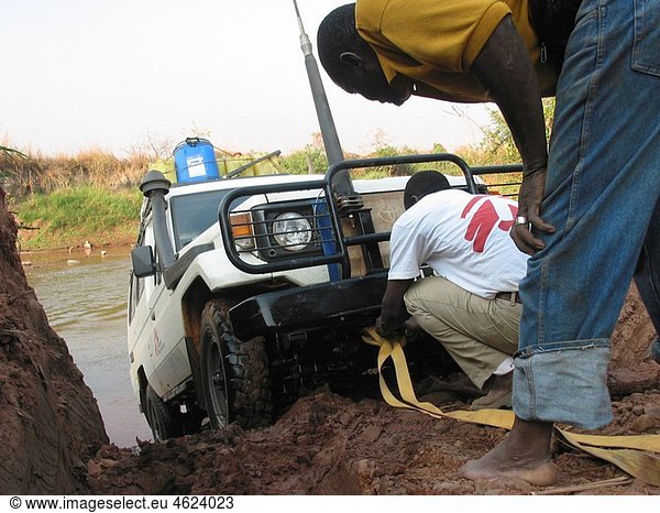 MSF staff prepare to help pull a vehicle up the muddy river bank Feeding centres and other humanitarian aid were organised in Angola after widescale malnutrition during and following the countryÂ¥s civil war