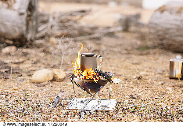 Mug on wood burning stove at ground