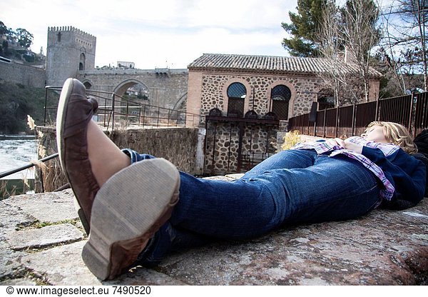 Mujer tumbada junto al Rio Tajo  Toledo  España