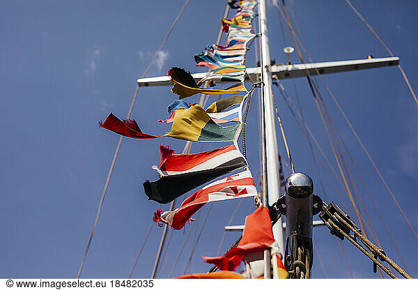 Multi colored national flags on yacht mast