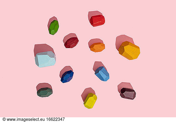 Multi colored wooden blocks against pink background