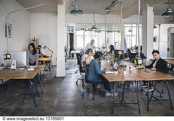 Multi-ethnic business people working at desks in office