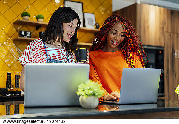 Multi-ethnic businesswomen working on laptop at office