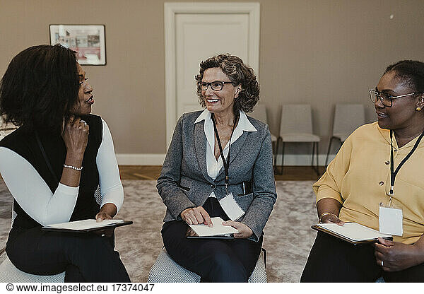 Multi-ethnic female colleagues discussing in meeting at education class