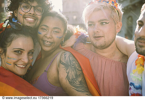Multi-ethnic male and female friends with arms around