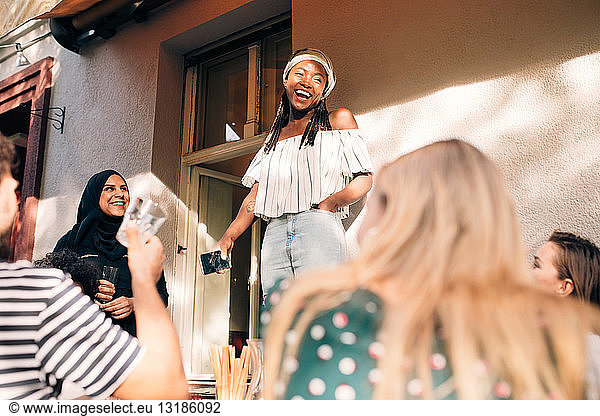 Multi-ethnic young friends celebrating at balcony during party