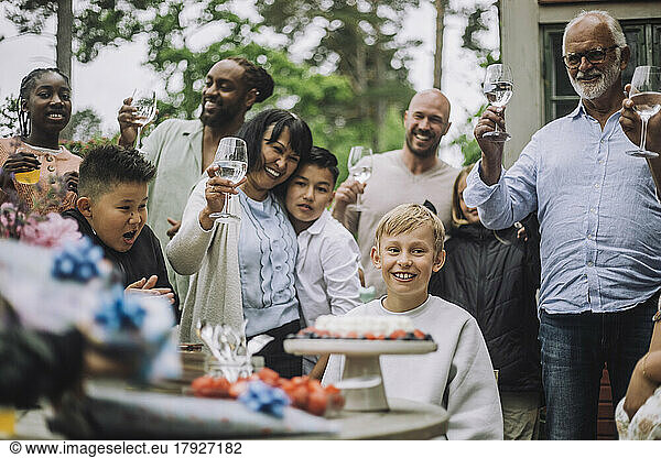 Multi-generation family cheering for boy during birthday celebration