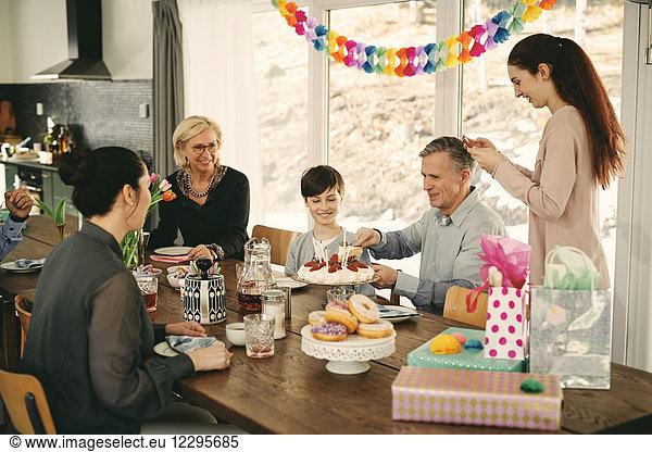 Multi-generation family enjoying birthday cake at table during party