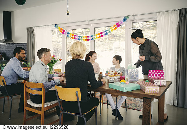 Multi-generation family enjoying food at birthday party