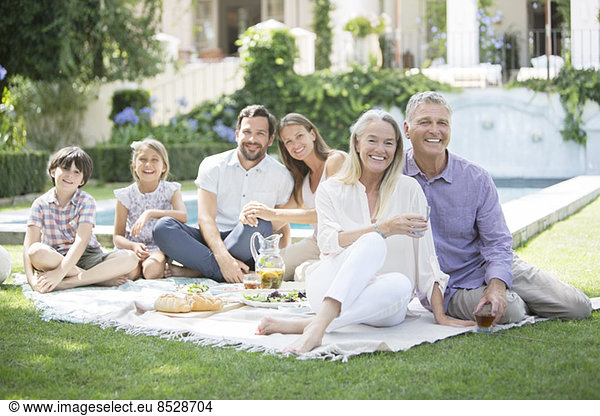 Multi-generation family enjoying picnic in backyard