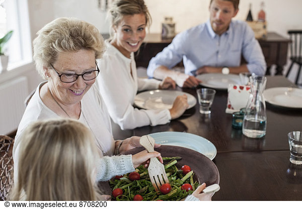 Multi-generation family having lunch at dining table