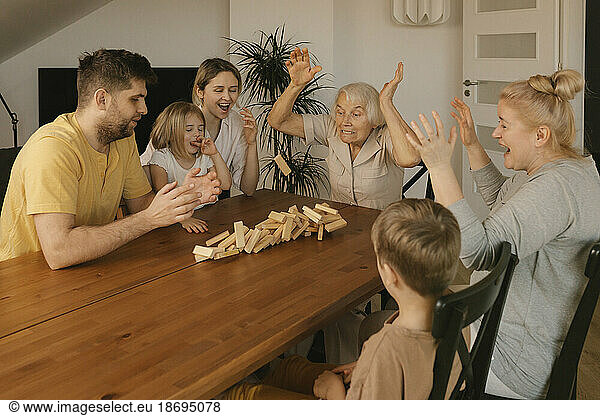 Multi-generation family playing leisure game on table at home