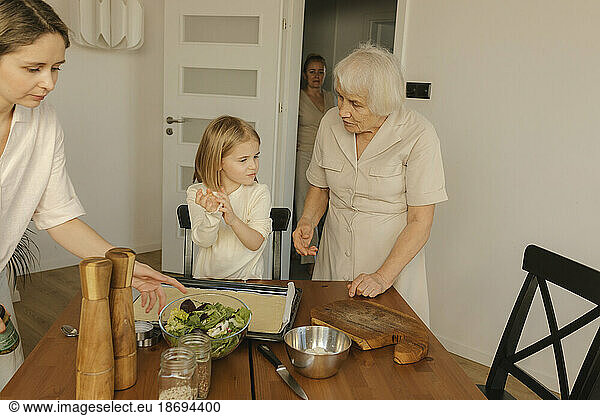 Multi-generation family preparing meal at home
