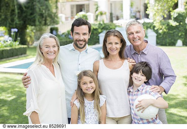 Multi-generation family smiling in backyard