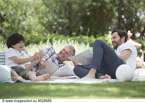 Multi-generation men relaxing on blanket in backyard