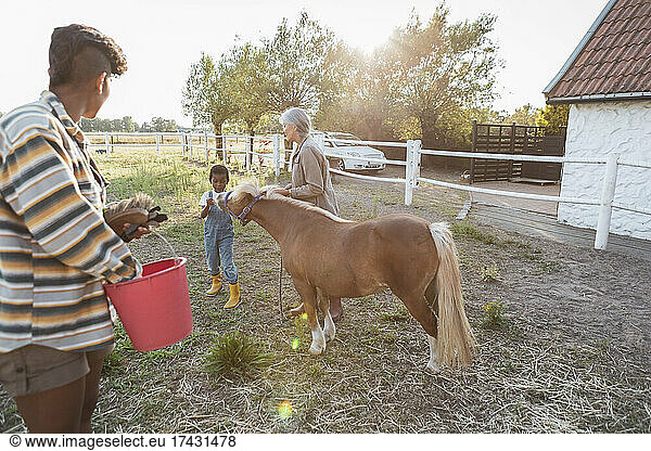 Multi-generational family with horse at farm