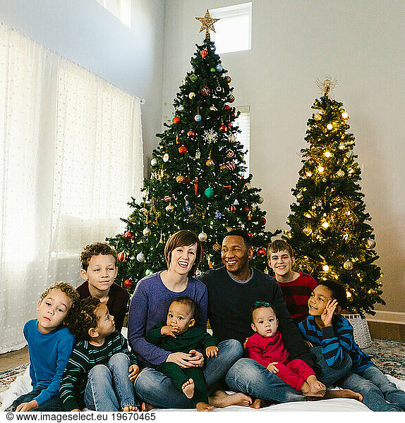 Multi racial family laughs and smiles together at Christmas