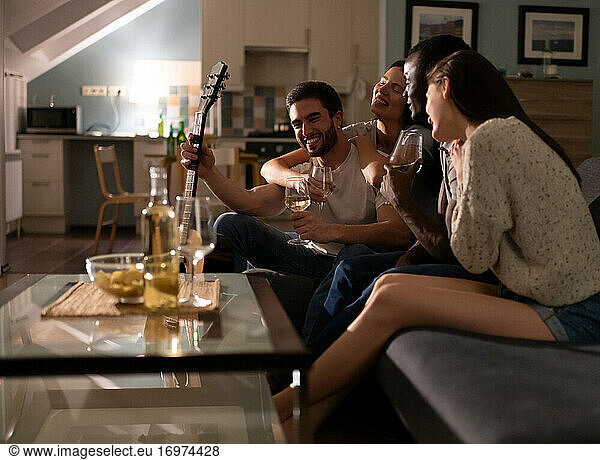 Multiethnic friends drinking wine in living room