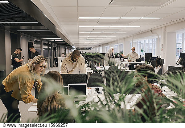 Multiethnische Fachleute diskutieren am Schreibtisch in einem offenen Büro