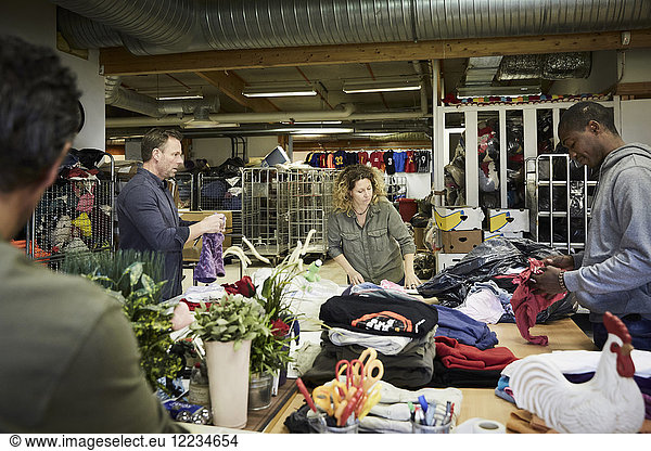 Multiethnische Freiwillige untersuchen Textilien im Lagerhaus