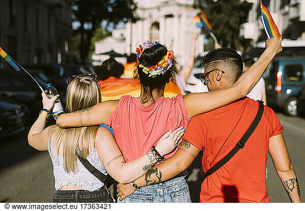 Multiethnische Freundinnen gehen auf der Straße während einer Pride-Veranstaltung