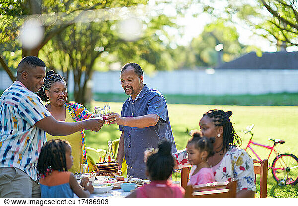 Multigenerational family celebrating birthday in summer backyard