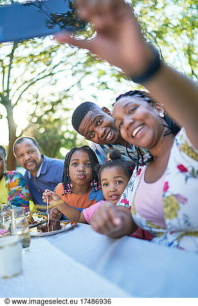 Multigenerational family taking selfie at patio table