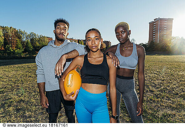 Multiracial American football players standing together in field