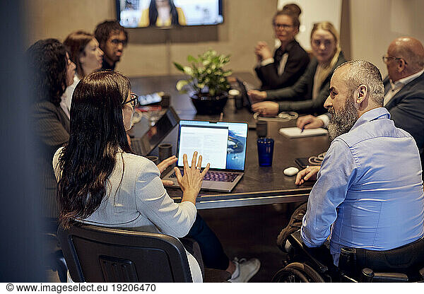 Multiracial business professionals discussing during conference call in board room