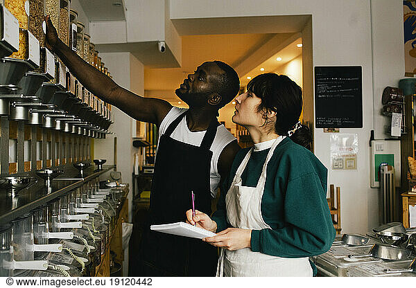 Multiracial colleagues checking inventory in food store