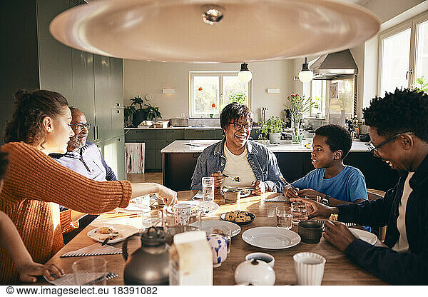 Multiracial family enjoying having food with each other at home