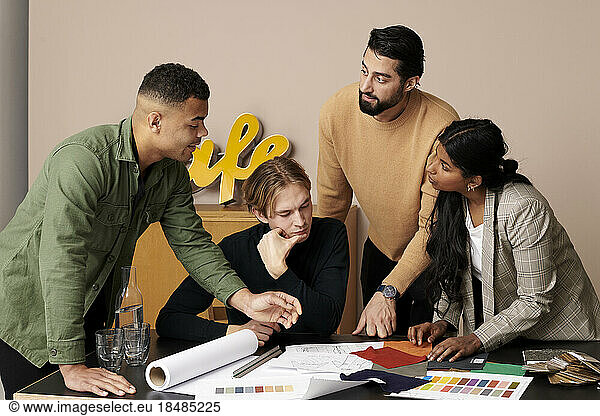 Multiracial fashion designers discussing in meeting at office